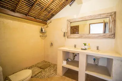 a bathroom with a sink and a toilet and a mirror at Villa Umah Maya in Seminyak