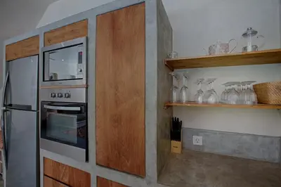 a kitchen with an oven and shelves with glass vases at Villa Inde Noi - Beautiful stylish bohemian 2bdrs villa - Kerobokan in Kerobokan