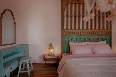 a bedroom with a bed and a mirror and a stool at Villa Inde Noi - Beautiful stylish bohemian 2bdrs villa - Kerobokan in Kerobokan