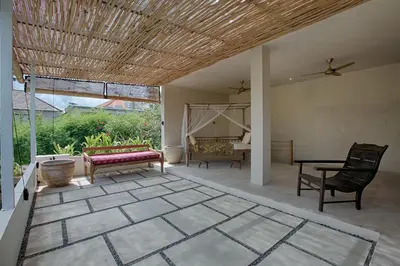 a patio with a couch and chairs and a table at Villa Inde Noi - Beautiful stylish bohemian 2bdrs villa - Kerobokan in Kerobokan