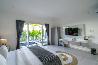 a white bedroom with a large bed and a television at The Kakadu - A new modern 2BR Villa with private pool in Seminyak in Seminyak