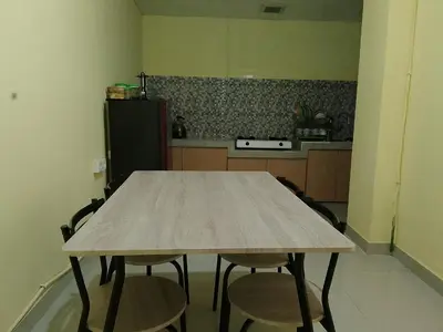 a wooden table in a kitchen with four chairs at Terace Campus A4 in Jimbaran