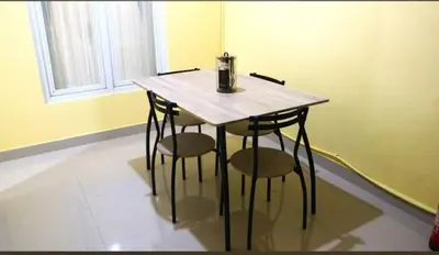 a wooden table with two stools in a room with a window at Terace Campus A4 in Jimbaran