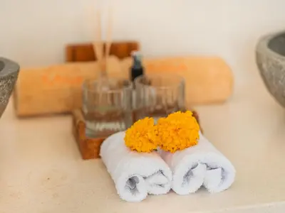 two towels with orange flowers on them on a counter at Lux 500sqm 5BR Villa, 400m to FINNS & Canggu Beach in Canggu