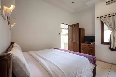 a bedroom with a white bed and a window at Putri Bali Seminyak Villa in Seminyak