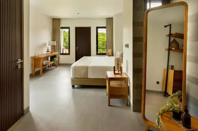 a bedroom with a bed and a mirror at Balidroomvilla Sanur Mangrove - Full Serviced - Beachside in Sanur