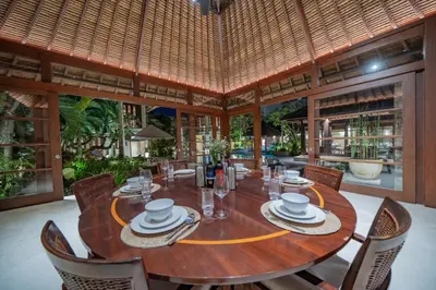 a dining room with a wooden table and chairs at Villa Wibisana Beachside Luxury in Seminyak in Seminyak