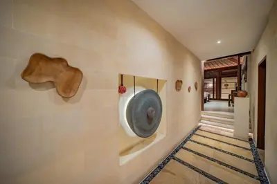 a hallway with a wall with sculptures on it at Villa Wibisana Beachside Luxury in Seminyak in Seminyak