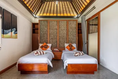 two twin beds in a room with a skylight at Beachside Villa Di Bucu in Canggu