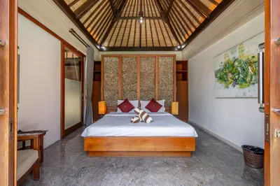 a bedroom with a bed with red pillows at Beachside Villa Di Bucu in Canggu