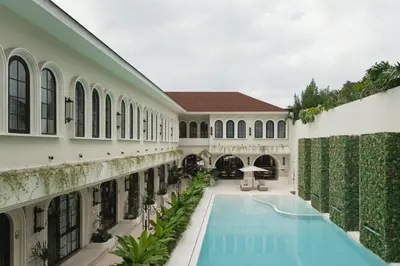 an exterior view of a building with a swimming pool at Hygge Hotel and Villas Seminyak in Seminyak