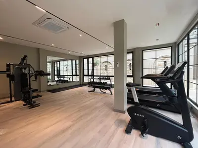 a gym with treadmills and ellipticals in a room with windows at Hygge Hotel and Villas Seminyak in Seminyak