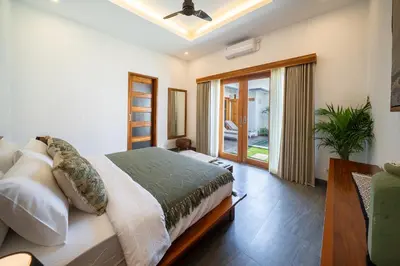a bedroom with a bed and a sliding glass door at Villa Mailaku Seminyak in Seminyak
