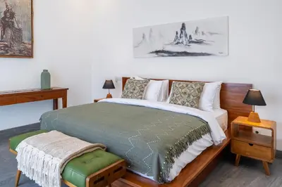 a bedroom with a large bed with a green blanket at Villa Mailaku Seminyak in Seminyak