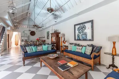 a living room with blue couches and a table at Villa Seni in Seminyak