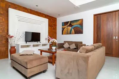 a living room with a couch and a tv at Bale Gede Luxury Villas by Moria in Canggu