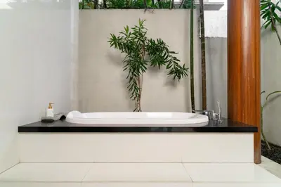 a bathroom with a bath tub with a potted plant at Bale Gede Luxury Villas by Moria in Canggu