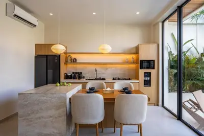 a kitchen with a wooden table and chairs at Villa Oasia 2 Seminyak in Seminyak