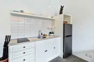 a kitchen with white cabinets and a stainless steel refrigerator at Perfect for Couples and Solo Travellers in Seminyak