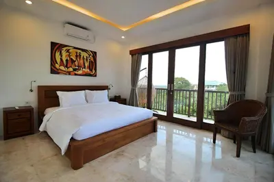 a bedroom with a large bed and a balcony at SummerVille Nusa Dua by REJA Villas in Nusa Dua