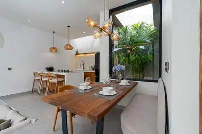 a dining room and kitchen with a wooden table at Villa Grace&Glory-2 bedroom villa near Canggu in Kerobokan
