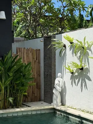 a statue sitting next to a pool in a backyard at Villa LYM BALI 3br with private pool in Legian