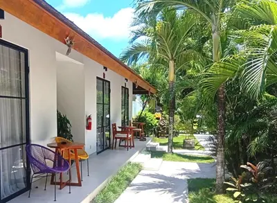 a patio with palm trees and a table and chairs at Nature's Immersion Room at Anwa Bali Boutique Resort in Canggu