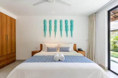 a bedroom with a white bed with two white towels on it at Nature's Immersion Room at Anwa Bali Boutique Resort in Canggu