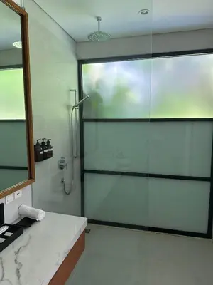 a bathroom with a shower with a glass door at Stunning Garden Room with Private Pool at Anwa Bali in Canggu