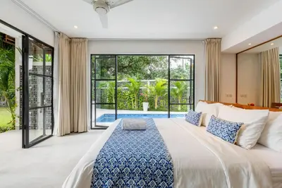 a bedroom with a large bed and large windows at Stunning Garden Room with Private Pool at Anwa Bali in Canggu