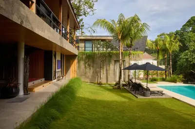 a house with a yard with a pool and an umbrella at The Riverfront 5BR Luxury Villa Near the Beach in Canggu