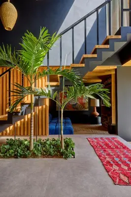a room with two palm trees and a staircase at The Riverfront 5BR Luxury Villa Near the Beach in Canggu