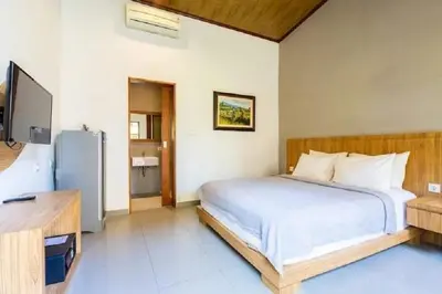 a bedroom with a bed and a television in it at The Tanjung Bidadari Seminyak in Seminyak