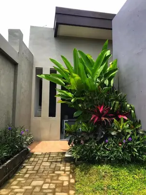 a garden in front of a building with plants at The Tanjung Bidadari Seminyak in Seminyak
