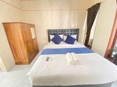 a bedroom with a bed with two slippers on it at SG Hotel - 2 Minutes to the Beach By Micky Studio 1 in Legian