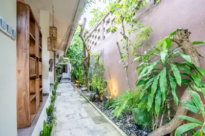 a garden corridor with plants and a building at Villa CC- Cosy 2bdrs villa - enclosed and open living area in Seminyak