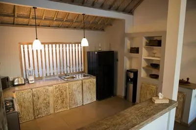 a kitchen with a sink and a black refrigerator at Two bedroom Villa in a beautyful tropical garden in Seminyak