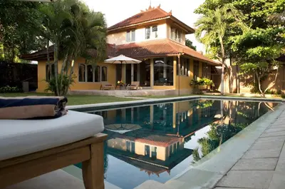 a house with a swimming pool in front of a house at Two bedroom Villa in a beautyful tropical garden in Seminyak