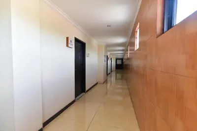 a hallway in a building with white walls and a door at RedDoorz Plus near Mall Bali Galeria 2 in Denpasar