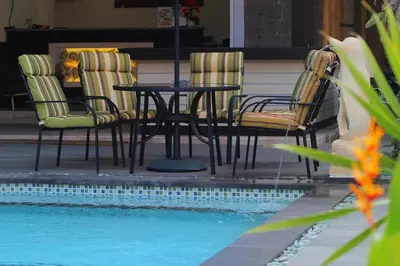 a table and chairs next to a swimming pool at Lotus Tirta Seminyak in Seminyak