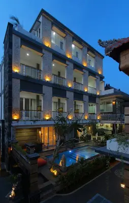 a building with a swimming pool in front of it at Lotus Tirta Seminyak in Seminyak
