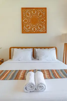 a bedroom with a bed with two towels on it at Comoda Seminyak in Seminyak