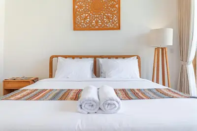 a bedroom with a bed with towels on it at Comoda Seminyak in Seminyak