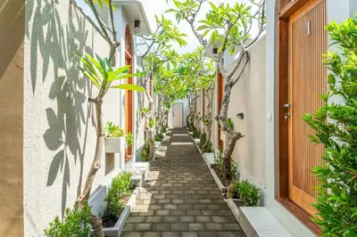 a narrow alley with trees on both sides at Comoda Seminyak in Seminyak