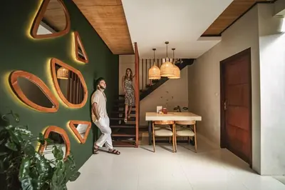 a man and a woman standing in a room with a staircase at Ini Vie Villa Seminyak by Ini Vie Hospitality in Legian