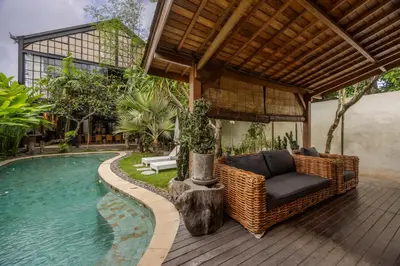 a patio with a couch and a chair next to a pool at 4 Bedrooms Brand New serenity Villa in Seminyak