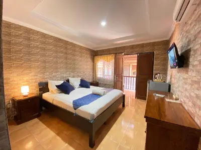 a bedroom with a bed and a television in it at ABI Hotel - 1 minute to the Beach and 1 second to the Mall in Ngurah Rai International Airport