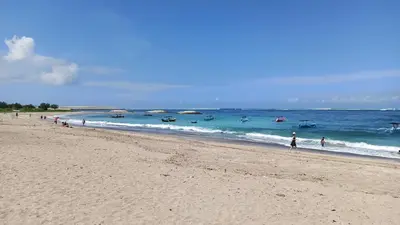 a group of people walking on a beach at ABI Hotel - 1 minute to the Beach and 1 second to the Mall in Ngurah Rai International Airport