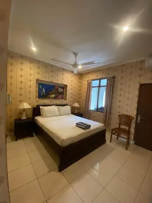 a bedroom with a bed and a chair and a window at SC Hotel - 1 Minute to the Beach By Micky Studio in Badung