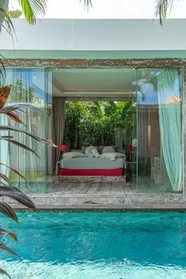 a bedroom with a bed and a swimming pool at Incredible 3BR Villa In The Heart Of Seminyak in Seminyak